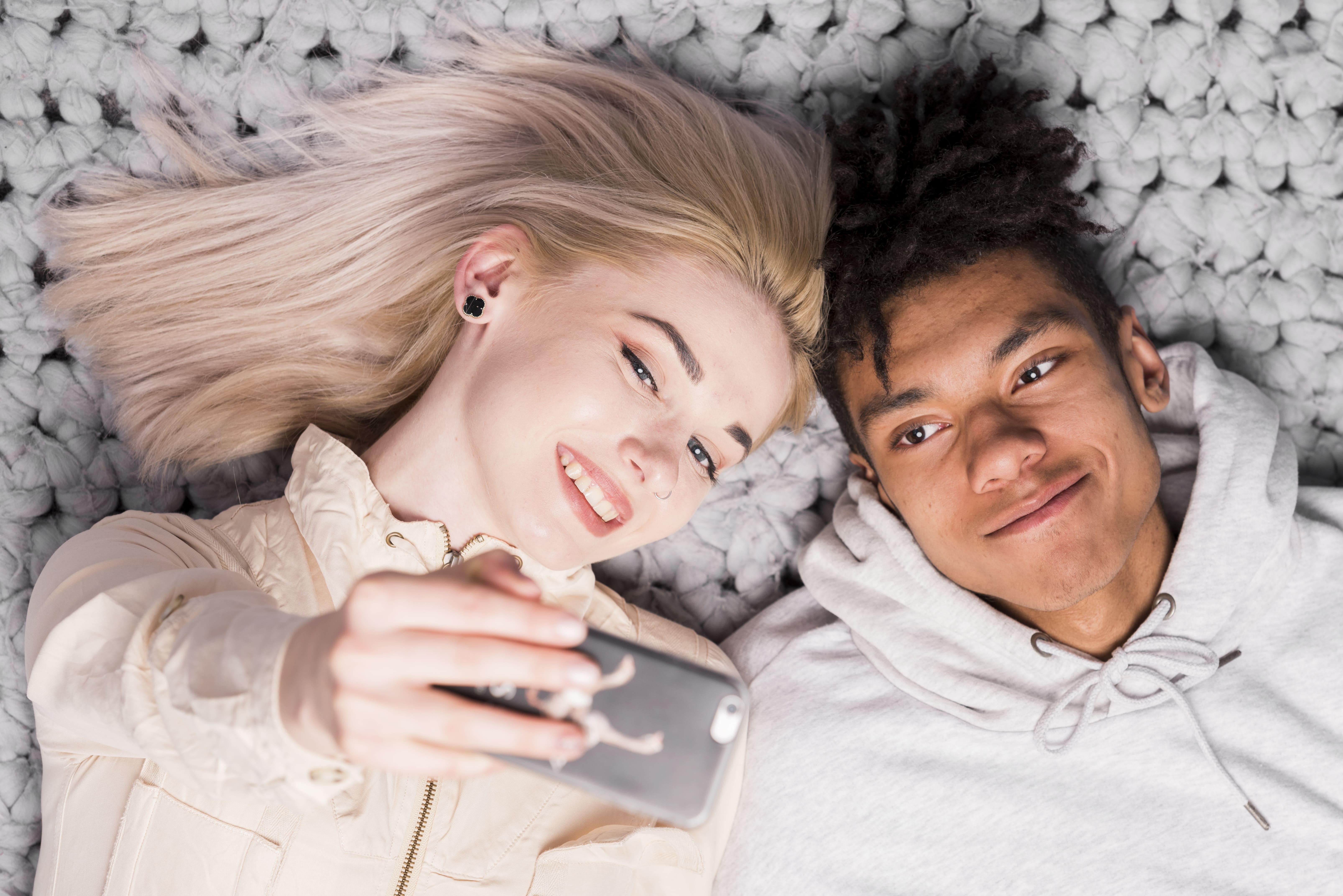 Couple s’amusant lors d’un shooting photo homemade sur leur tapis de salon