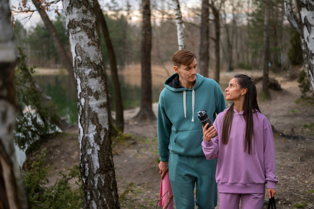 Couple en balade en forêt à la fin d'une course à pied, profitant d’un moment sans écrans